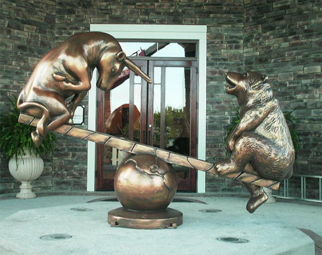 Bronze statue of bull and bear on teeter totter over world - Sam Hebert Financial Sign - Lake Charles LA 