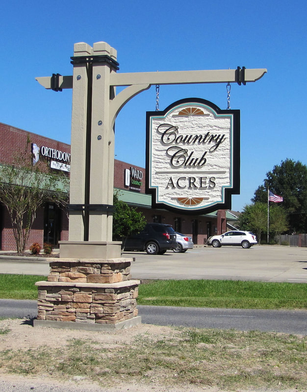 Photo of Country Club Acres sign - routed HDU hanging from multiple cedar beam structure wit stone base - custom signs - lake charles LA